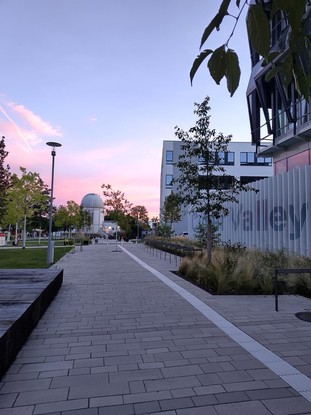 Pink evening clouds above the paved walkway and the observatory dome at Cyber Valley